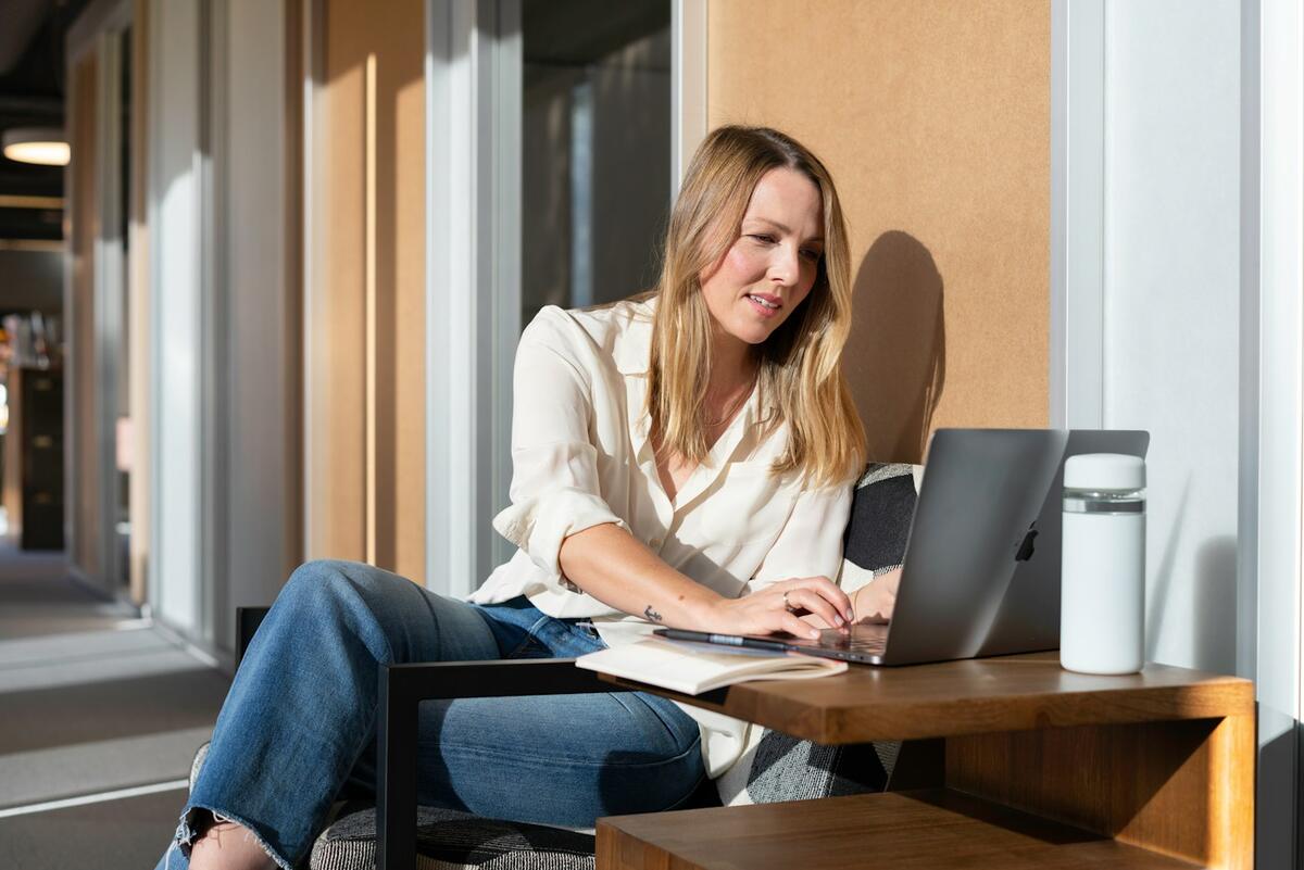 Glimlachende vrouw aan het werk in het zonlicht